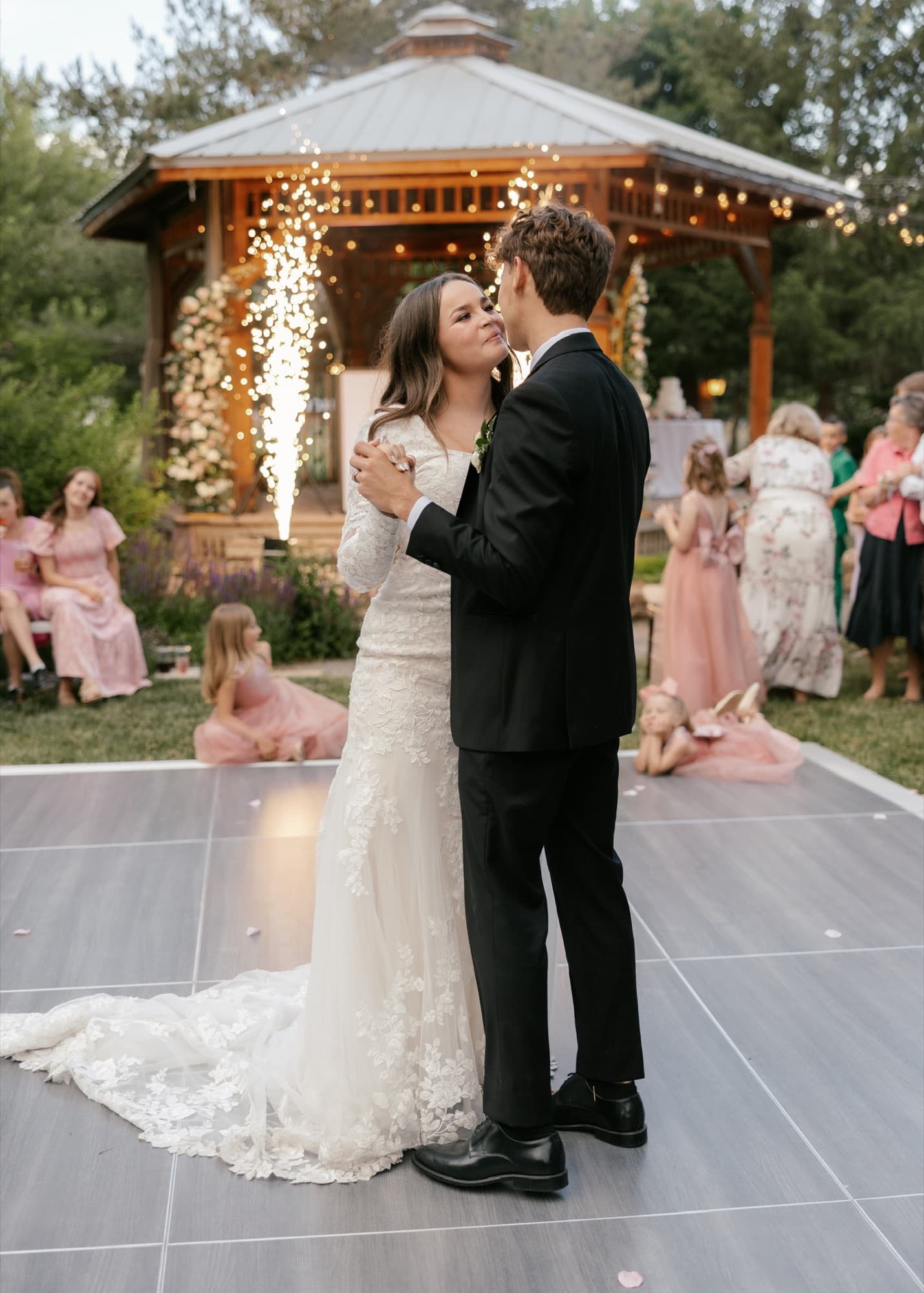 Newlyweds sharing an outdoor first dance between cold spark fountains