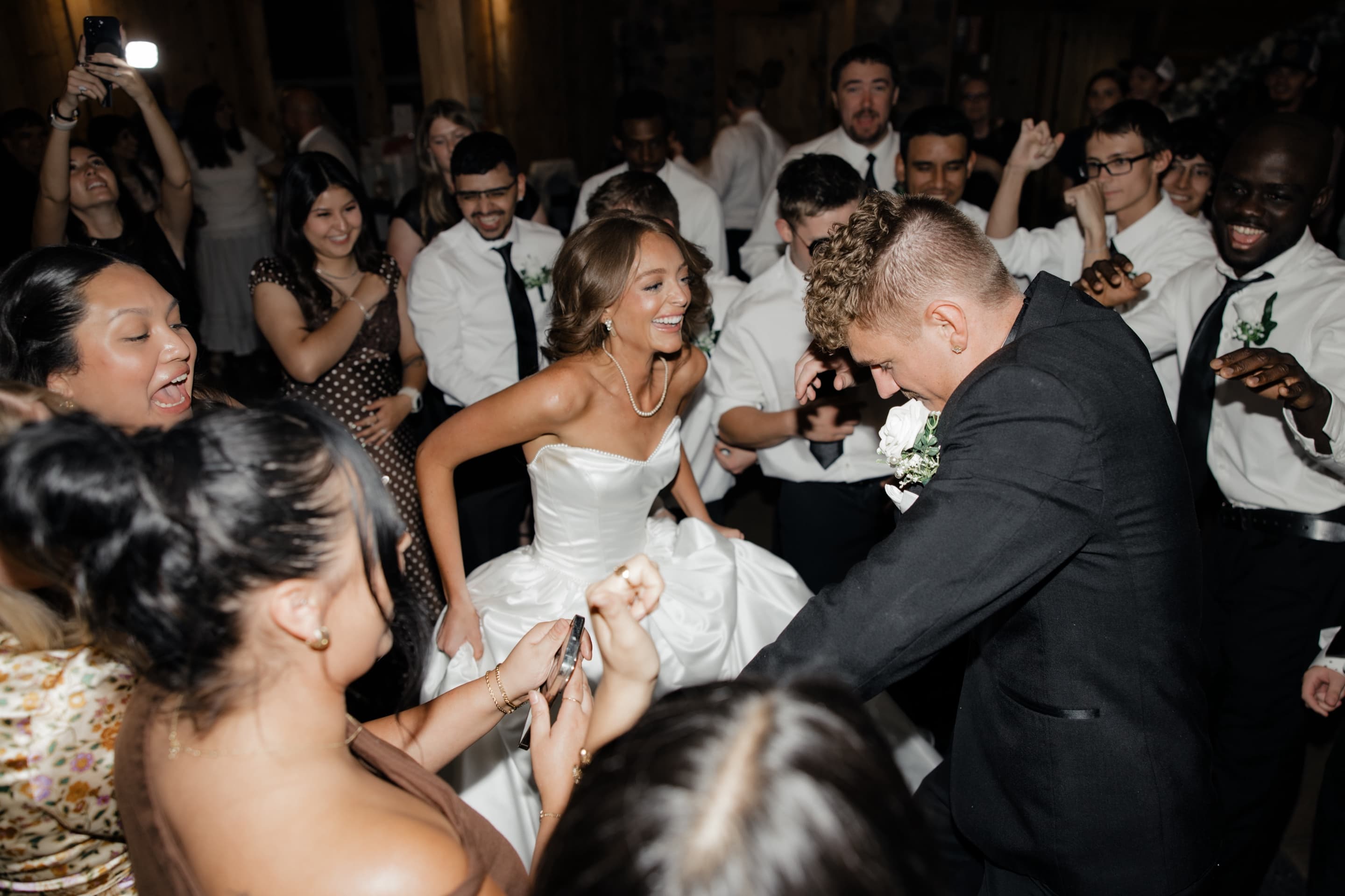 Bride and groom dancing with their guests on a packed wedding dance floor