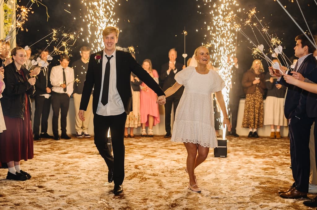 Newlyweds celebrating a cold spark exit with their guests