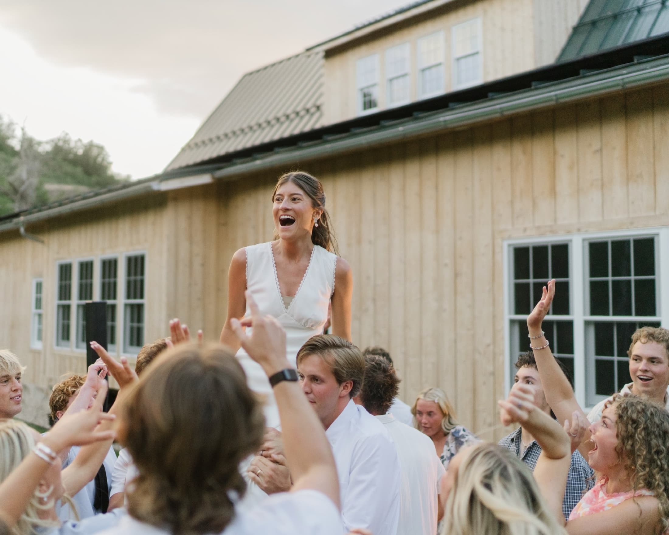 Wedding guests lifting the bride above the dance floor