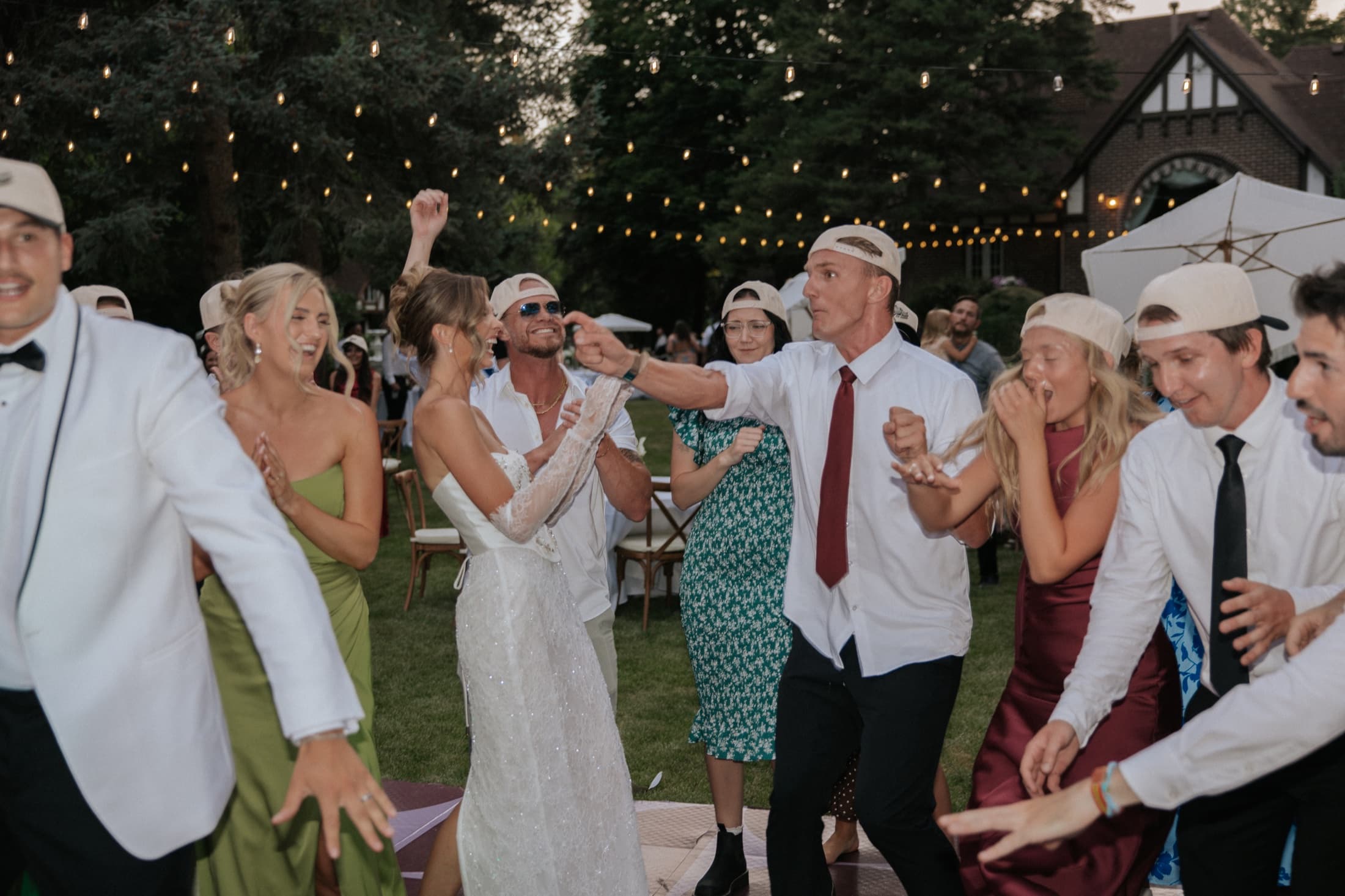 Bride surrounded by cheering guests on an outdoor wedding dance floor
